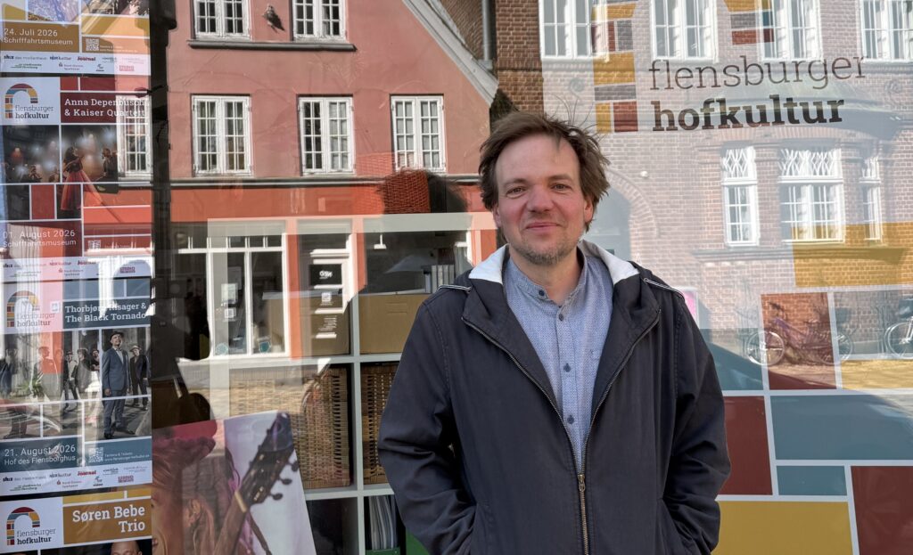 Das Bild zeigt Gunnar Astrup vor seinem Büro in der Flensburger Norderstraße