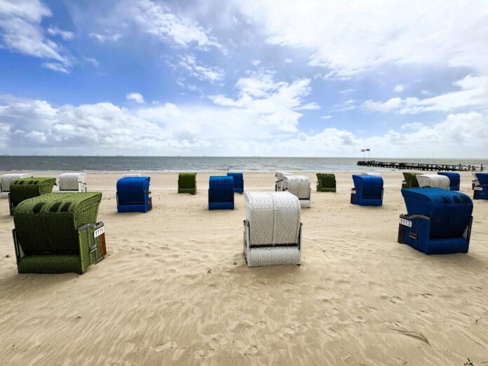 Aufgereihte Strandkörbe von hinten mit Blick aufs Wasser am Föhrer Südstrand.