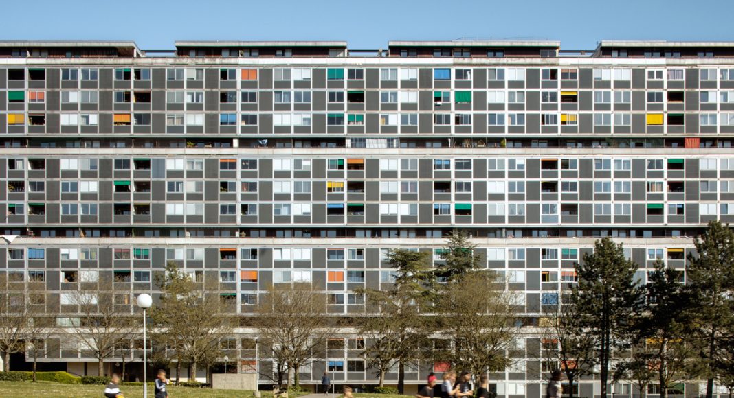 Le Lignon umfasst 2.700 Wohnungen auf mehr als einem Kilometer Länge. Aufgrund der einzigartigen topografischen Lage und der innovativen Curtain-Wall-Fassade wurde die Anlage 2009 unter Denkmalschutz gestellt – und von den neun Bauträgern, Betreibern, Eigentümern und Genossenschaften umfassend saniert. Foto: Paola Corsini